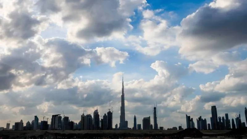 Partly cloudy skies over the United Arab Emirates with cumulus clouds indicating expected rainfall in eastern and inland areas.