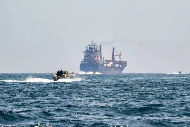 A maritime vessel navigating through the Strait of Hormuz, a strategically vital waterway between Oman and Iran.