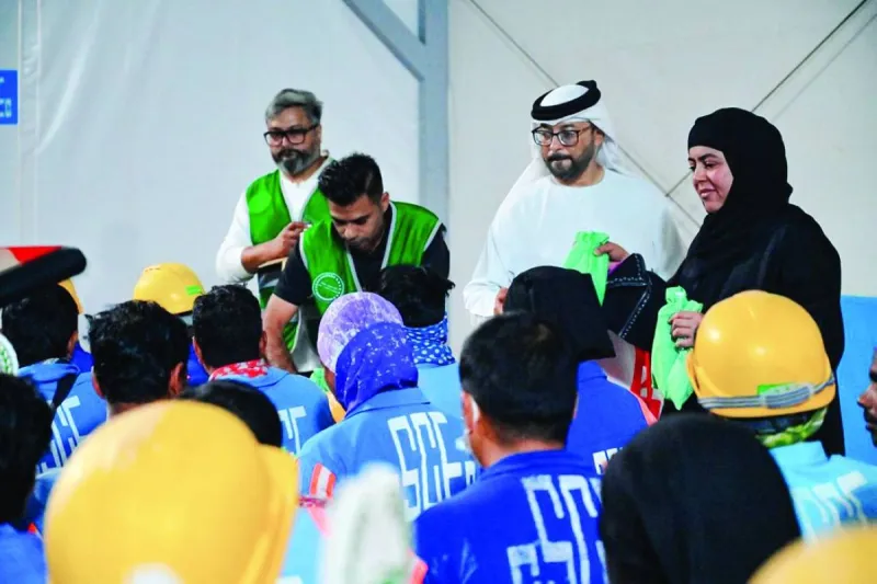 Dubai Police volunteers distribute summer essentials including umbrellas and cold refreshments to workers at a residential area in Dubai.
