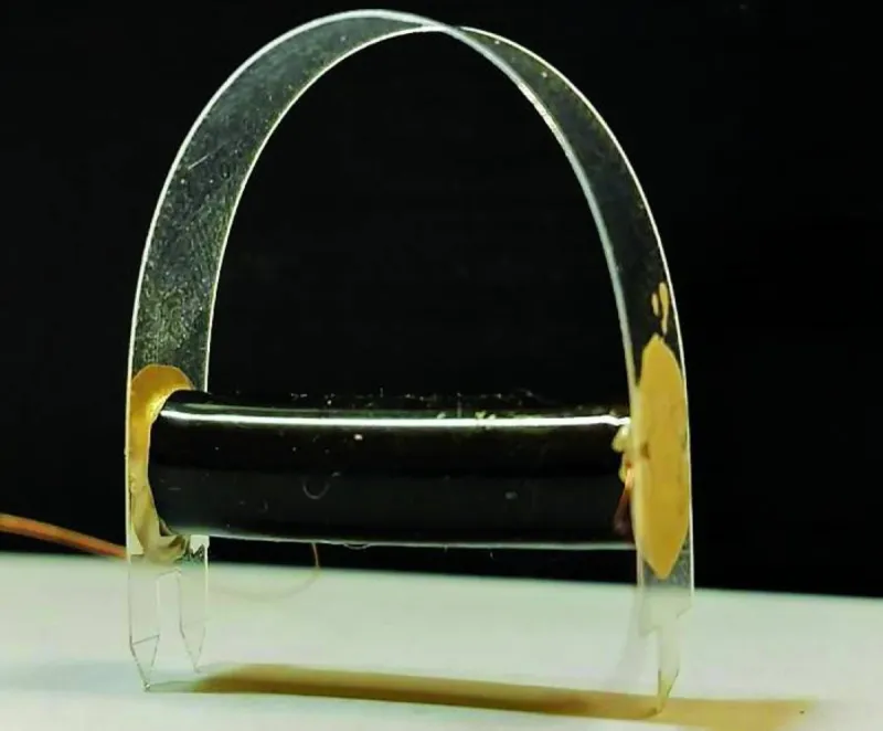 A microscopic flexible robot composed of alternating polymer and carbon electrode layers, approximately the thickness of a human hair.