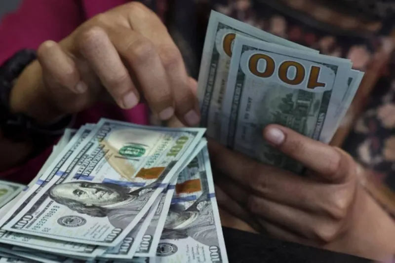 A US dollar banknote alongside other major currencies, illustrating the dollar's broad-based gains driven by expectations of a US interest rate hike.