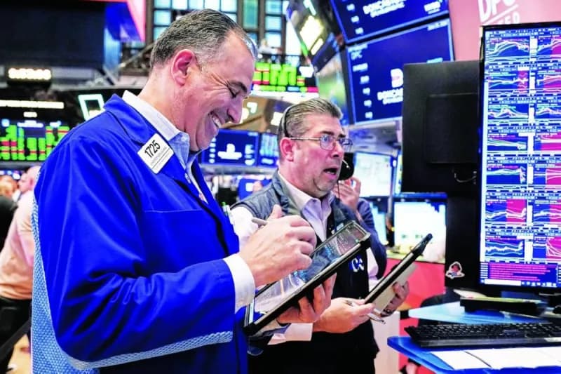 A trading screen displays stock market indices showing record highs in major global markets amid a rally driven by AI and semiconductor stocks.