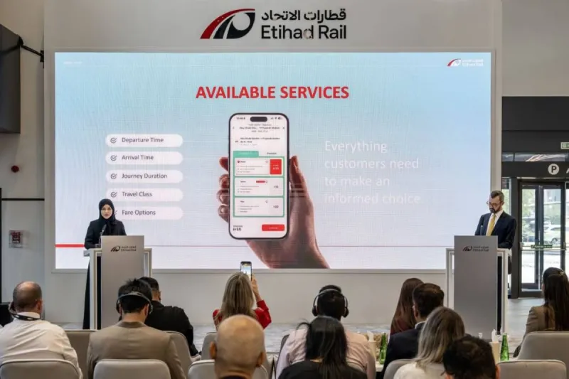 Passengers browse the Etihad Rail digital app to book tickets for the new UAE passenger train service.