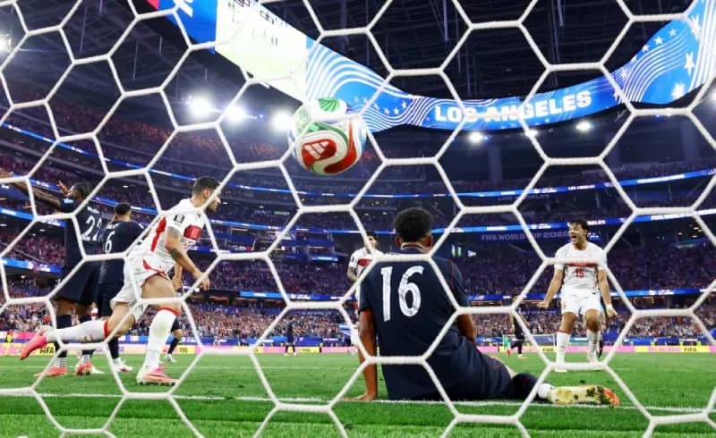 A scene from the United States versus Turkey World Cup group stage match, with players contesting the ball on the pitch.