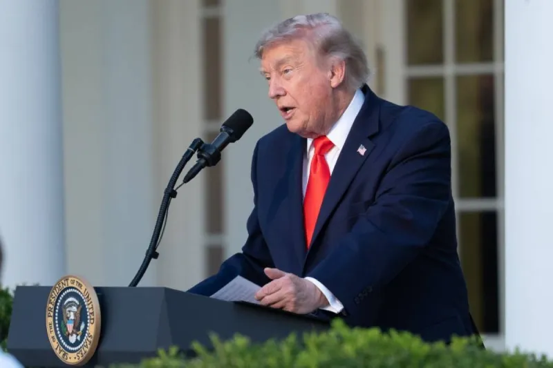 US President Donald Trump speaks at a podium, gesturing as he addresses reporters.