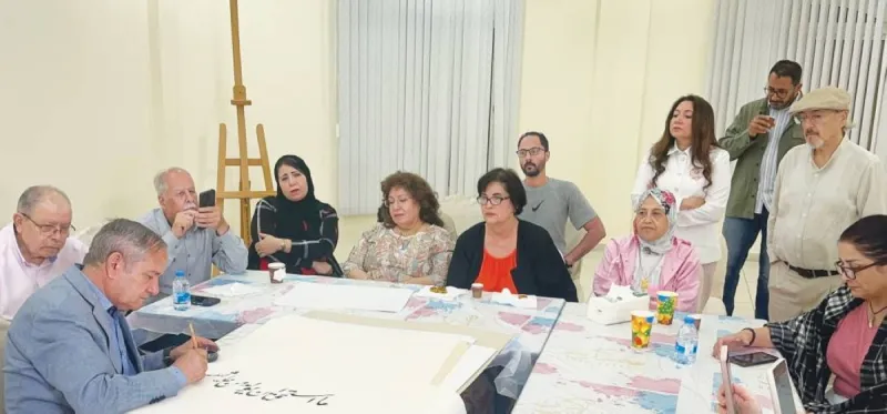 Calligrapher Khalifa Al Shaimi demonstrating Arabic calligraphy techniques during an artistic workshop organised by the Arab Cultural Club.