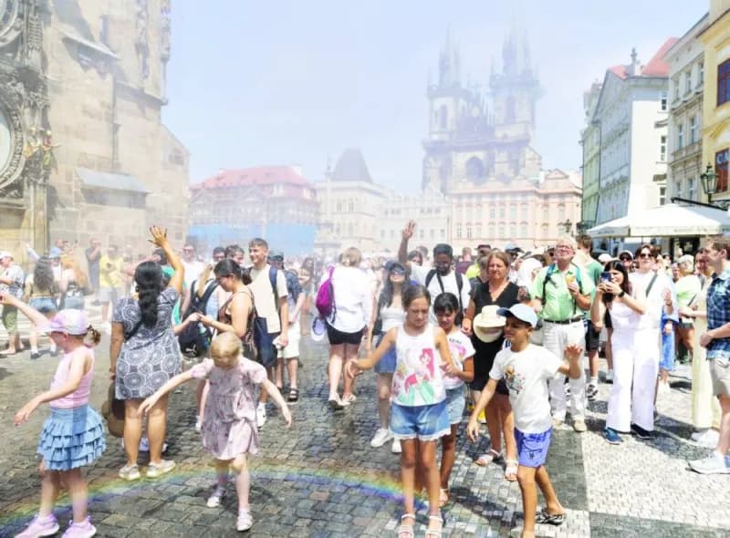 A person seeks shade during an extreme heatwave in a European city, with a thermometer visible in the sweltering summer heat.