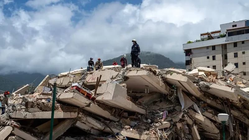 Rescue workers searching through rubble of collapsed buildings in La Guaira, Venezuela, following a devastating earthquake.