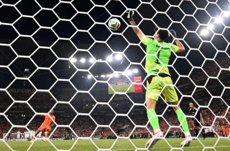 Moroccan goalkeeper Yassine Bono stands his ground to make a penalty save during a 2026 FIFA World Cup match.