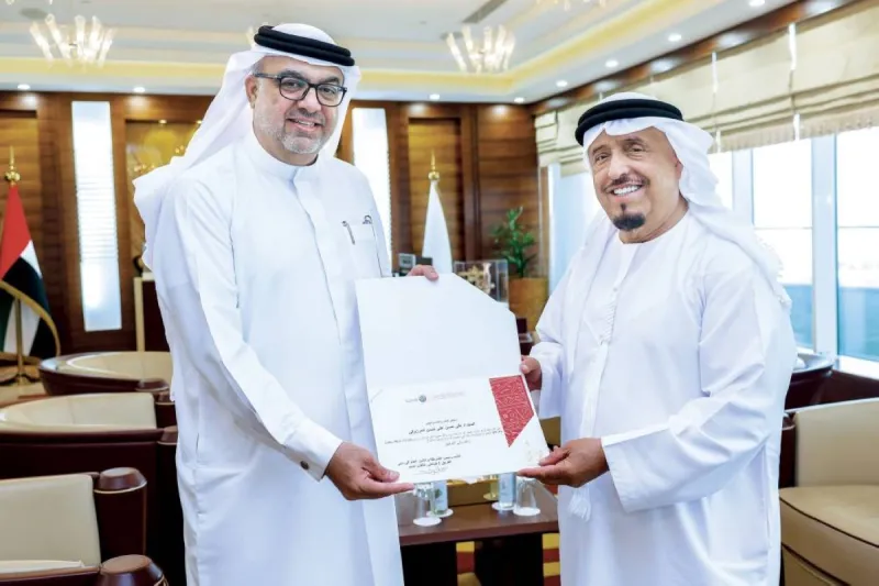 Lieutenant General Dhahi Khalfan Tamim presenting an honour to Ali Hassan Al Marzouqi, the innovator behind Dubai Police's luxury patrol car fleet concept, at his office in Dubai.