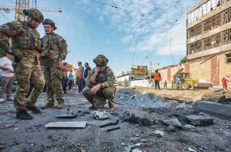 Smoke rising over a Ukrainian city following a Russian missile and drone strike, with emergency responders on the ground.