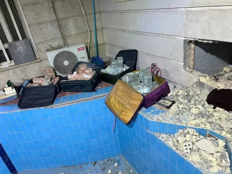 Iraqi security forces displaying seized cash and gold bars confiscated during anti-corruption raids on officials' homes in Baghdad.