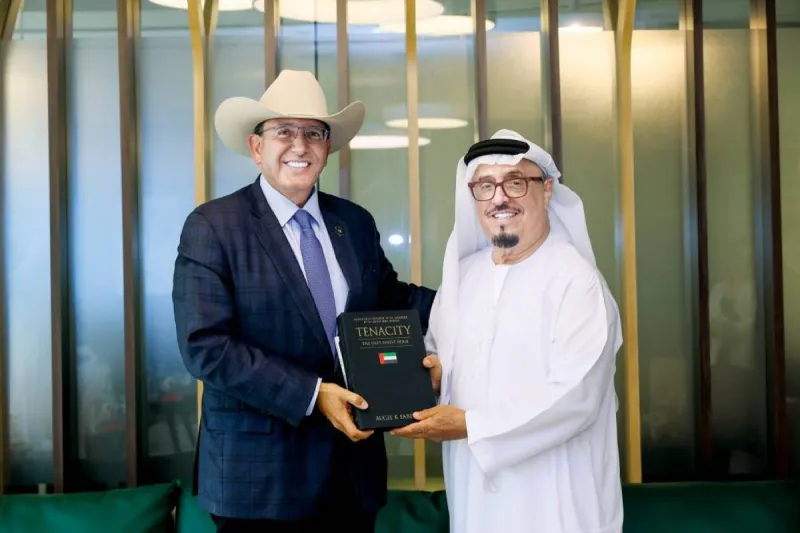 Lieutenant General Dhahi Khalfan Tamim receives a copy of the book 'Tenacity: The UAE's Finest Hour' from its author Augie K. Fabela II at the Dubai Police Officers Club.