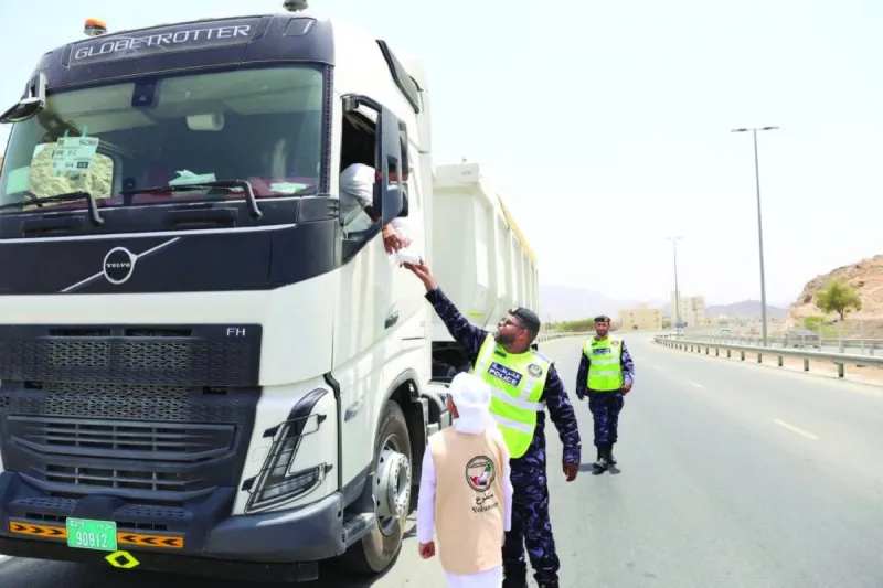 Members of Ajman Police and the UAE Pulse Volunteer Team distributing meals and beverages to truck drivers during the 'Street of the Nation' initiative in Masfout.