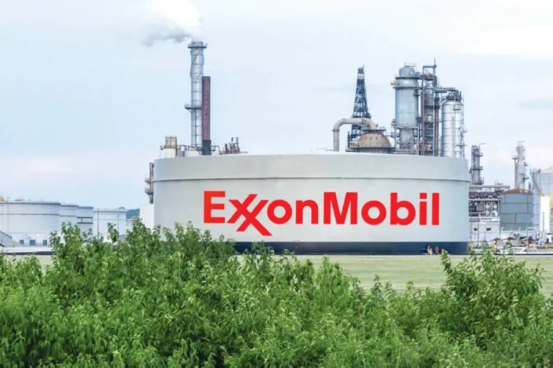 An oil refinery facility with large storage tanks and industrial infrastructure, representing the US energy sector's record quarterly earnings.