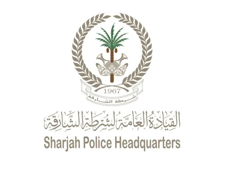 Sharjah Police officers displaying seized items including bank cards, passports, electronic devices, and documents recovered during the electronic fraud network operation.
