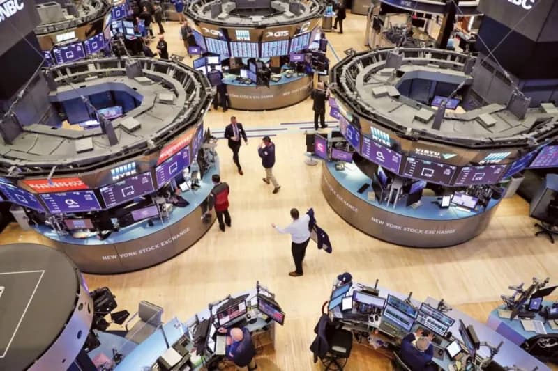 A busy Wall Street trading floor with traders monitoring screens showing stock market data, with semiconductor and technology stocks prominently featured.