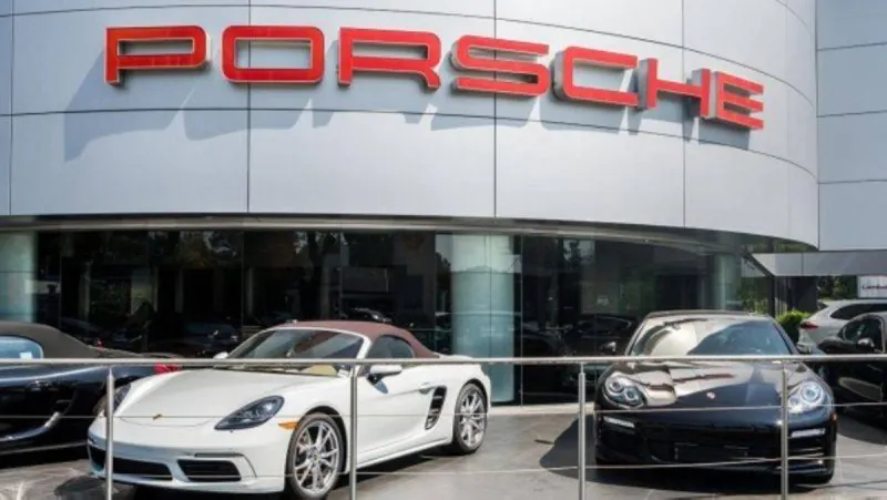 A Porsche sports car on display at a dealership or motor show, representing the German automaker amid its announced restructuring and job cuts.