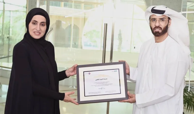 Najla Saif Al Shamsi receiving a certificate of appreciation on behalf of Al Bahth Al Ilmi Schools from the Awqaf and Minors Affairs Foundation in Dubai.