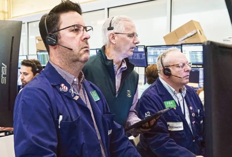 A trader monitors stock market data on screens displaying global equity indices and technology sector movements.