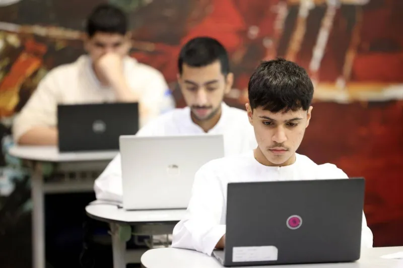 A student sits at a desk taking a written exam at a UAE government school.