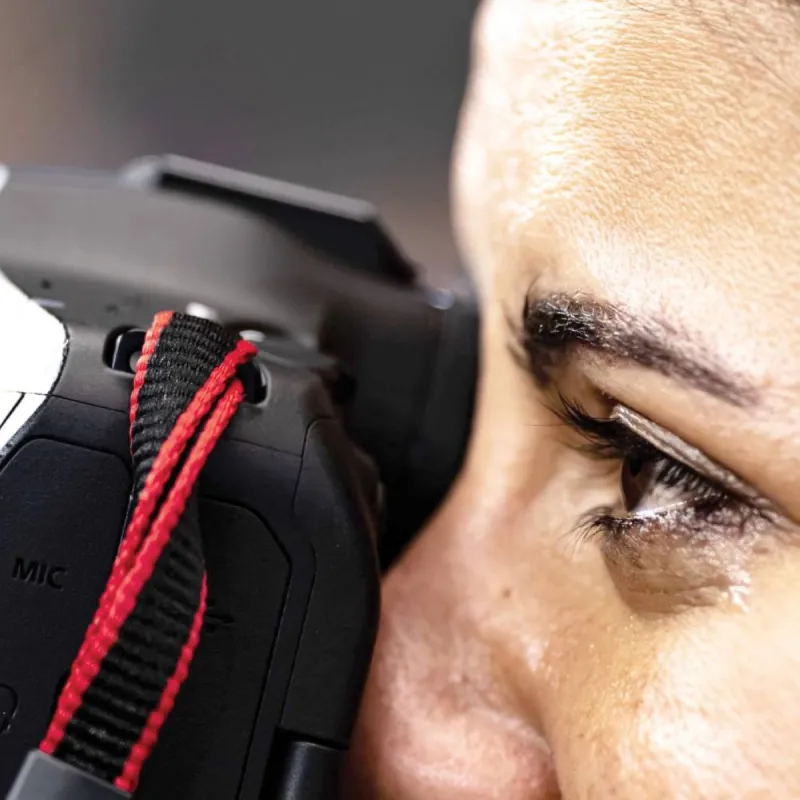 Egyptian sports photographer Samah Zidan photographed from the sidelines while crying tears of joy during Egypt's World Cup match, still holding her camera.