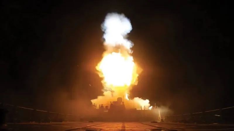 Smoke rising over a coastal military installation following US strikes on Iranian targets along the Strait of Hormuz.