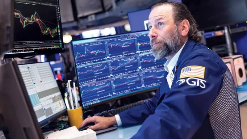 Traders monitor global stock market indices on screens as equities diverge amid rising US-Iran tensions and climbing oil prices.