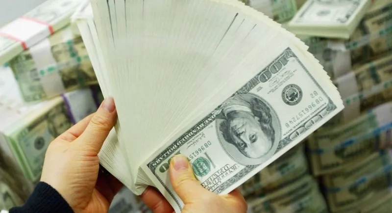 Currency trading screens displaying the US dollar index and exchange rates against major currencies including the yen and euro.