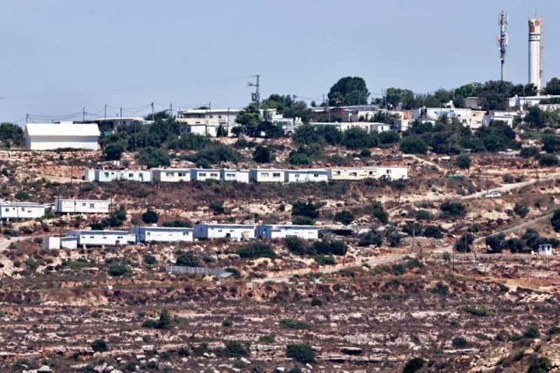 Israeli settlement construction in the occupied West Bank, with clusters of new residential buildings visible on hillside terrain.