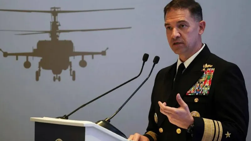 Admiral Brad Cooper, Commander of United States Central Command, speaking at an official podium regarding Iranian attacks on commercial vessels in the region.