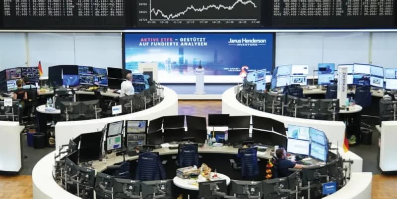 European stock exchange trading floor with digital screens displaying falling market indices amid Middle East tensions.