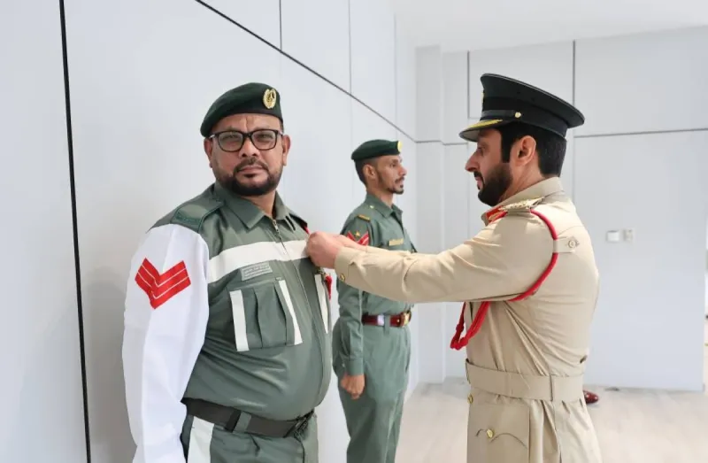Senior Corporal Ahmed Mohammed Salem and Sergeant Omar Muslim Aflatoun receive badges of appreciation from Major General Dr. Ahmed Zaal bin Krishan Al Muhairi at a Dubai Police ceremony.